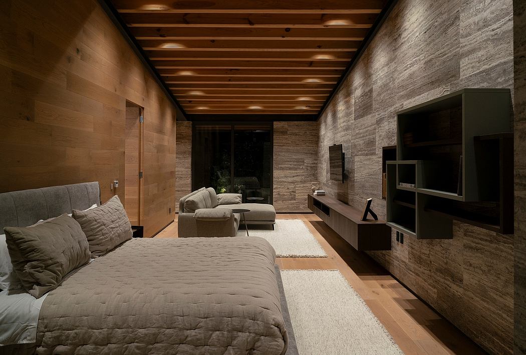 Cozy, rustic bedroom with wooden ceiling, stone walls, and minimalist furniture.