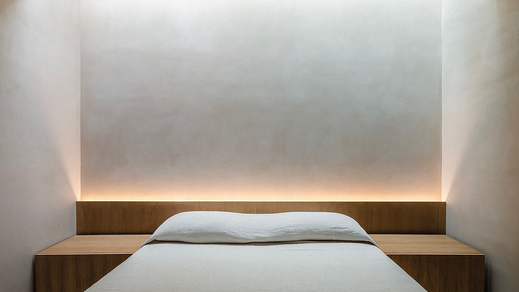 Minimalist bedroom design with wooden headboard and nightstands, soft lighting.