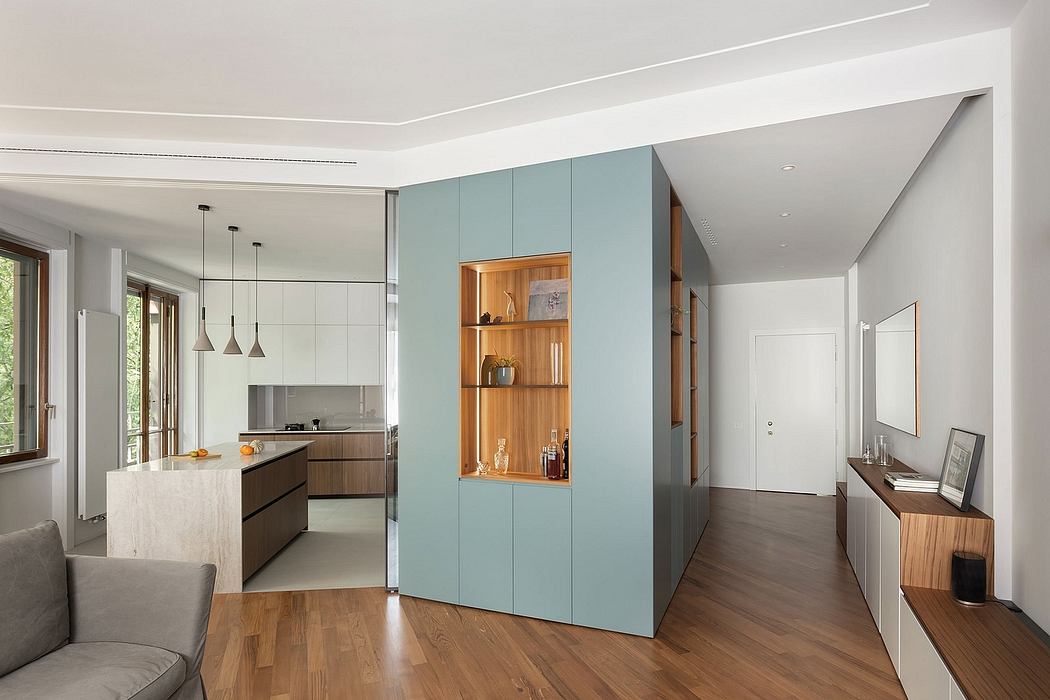 Spacious, open-concept living area with modern kitchen, built-in shelving, and wood flooring.