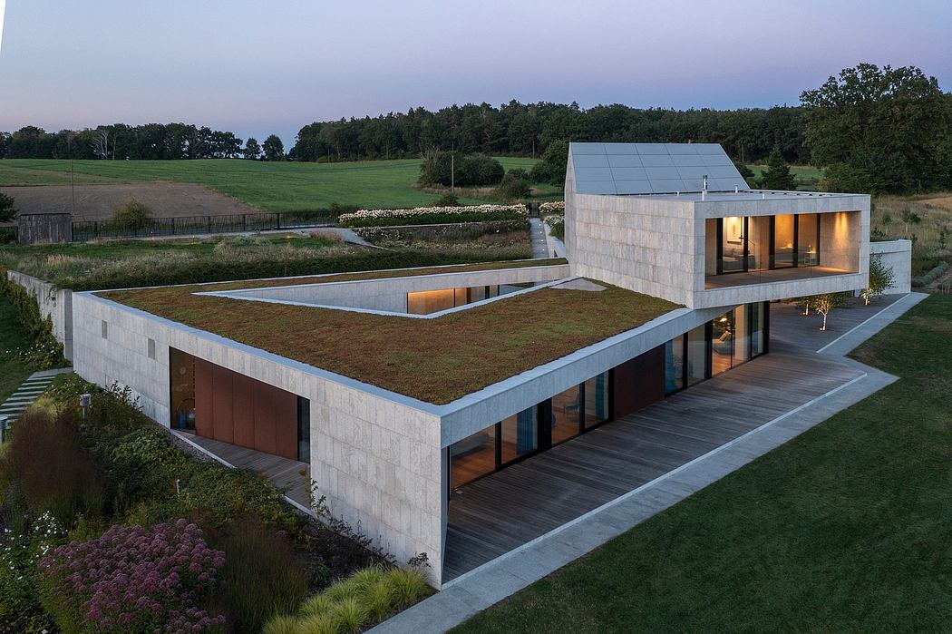 A modern architectural masterpiece with a striking concrete exterior, expansive windows, and lush green roof.