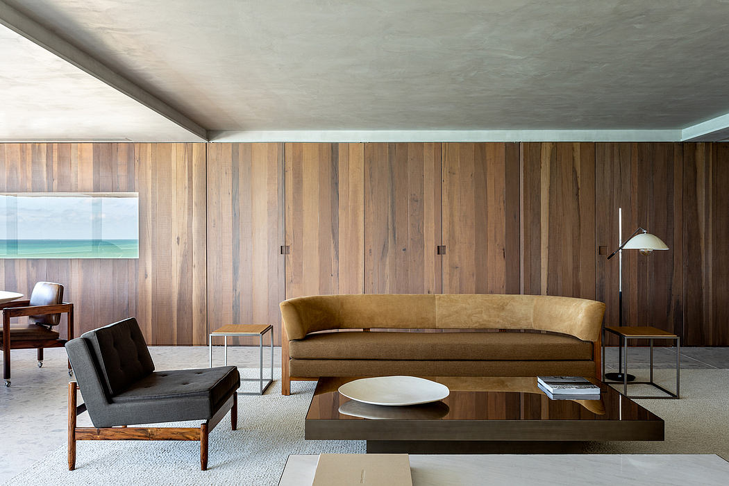 Warm, rustic living room with wooden paneling, a curved couch, and minimalist furnishings.