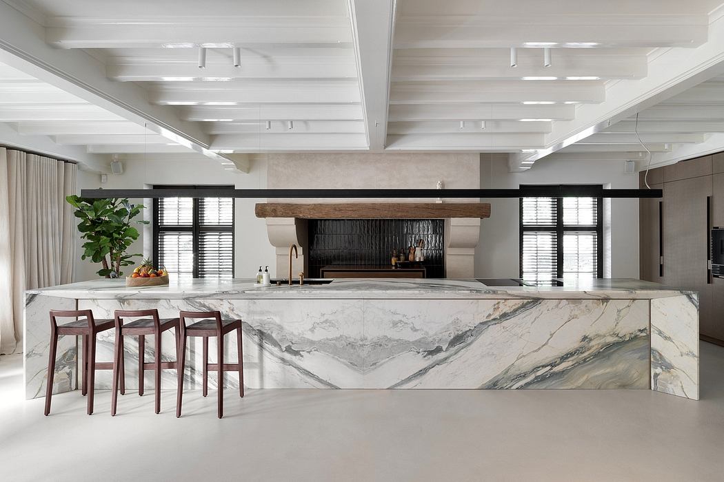 Spacious kitchen with modern marble countertop, wood-beam ceiling, and industrial lighting.