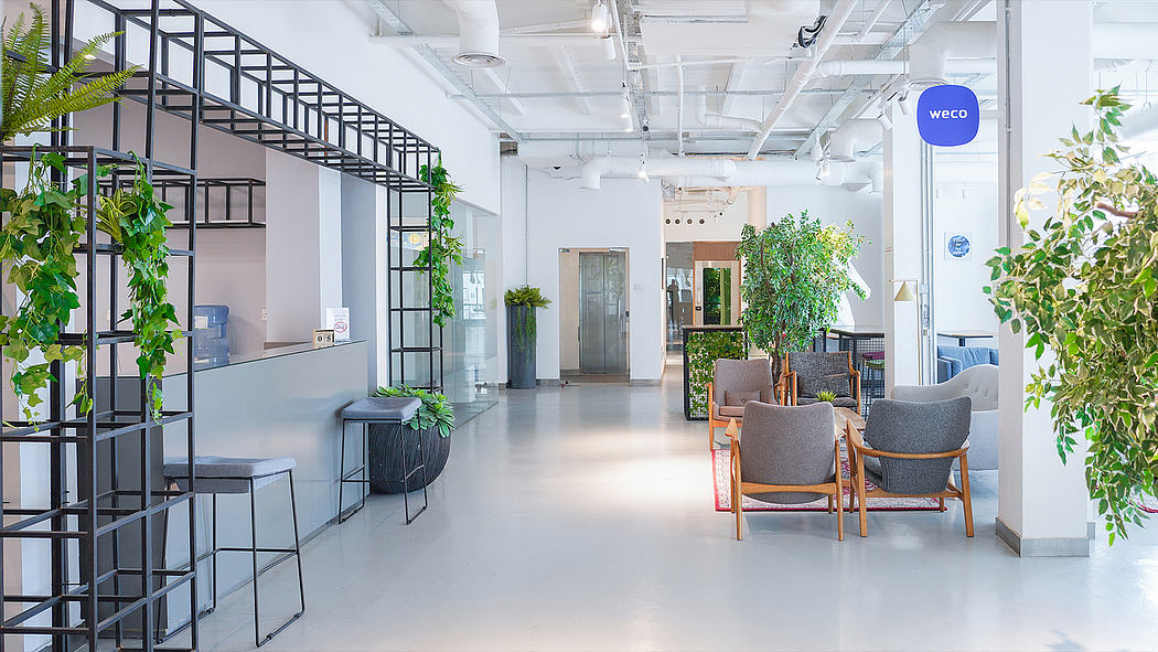 Sleek industrial-style office space with metal frames, greenery, and modern furniture.