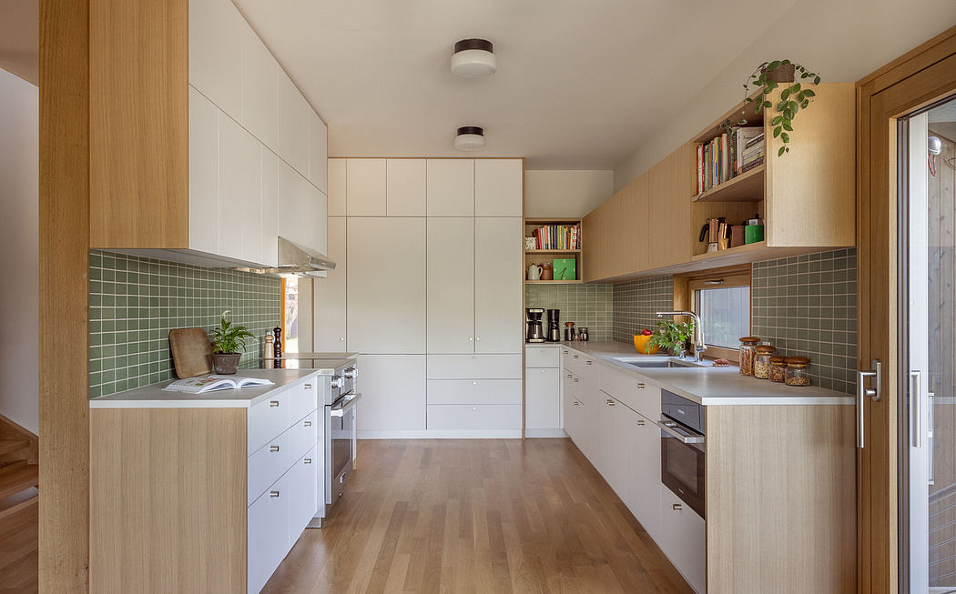 Modern kitchen with clean white cabinetry, wood floors, and tiled backsplash.