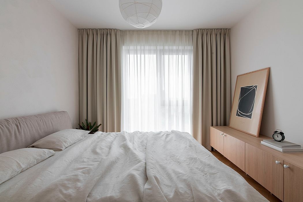 Cozy bedroom with plush bedding, minimalist furniture, and textured curtains.