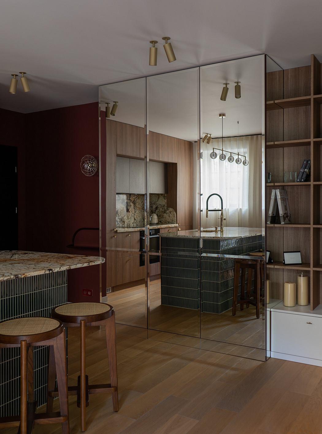 Sleek modern kitchen with wooden cabinetry, metal accents, and glass partition.