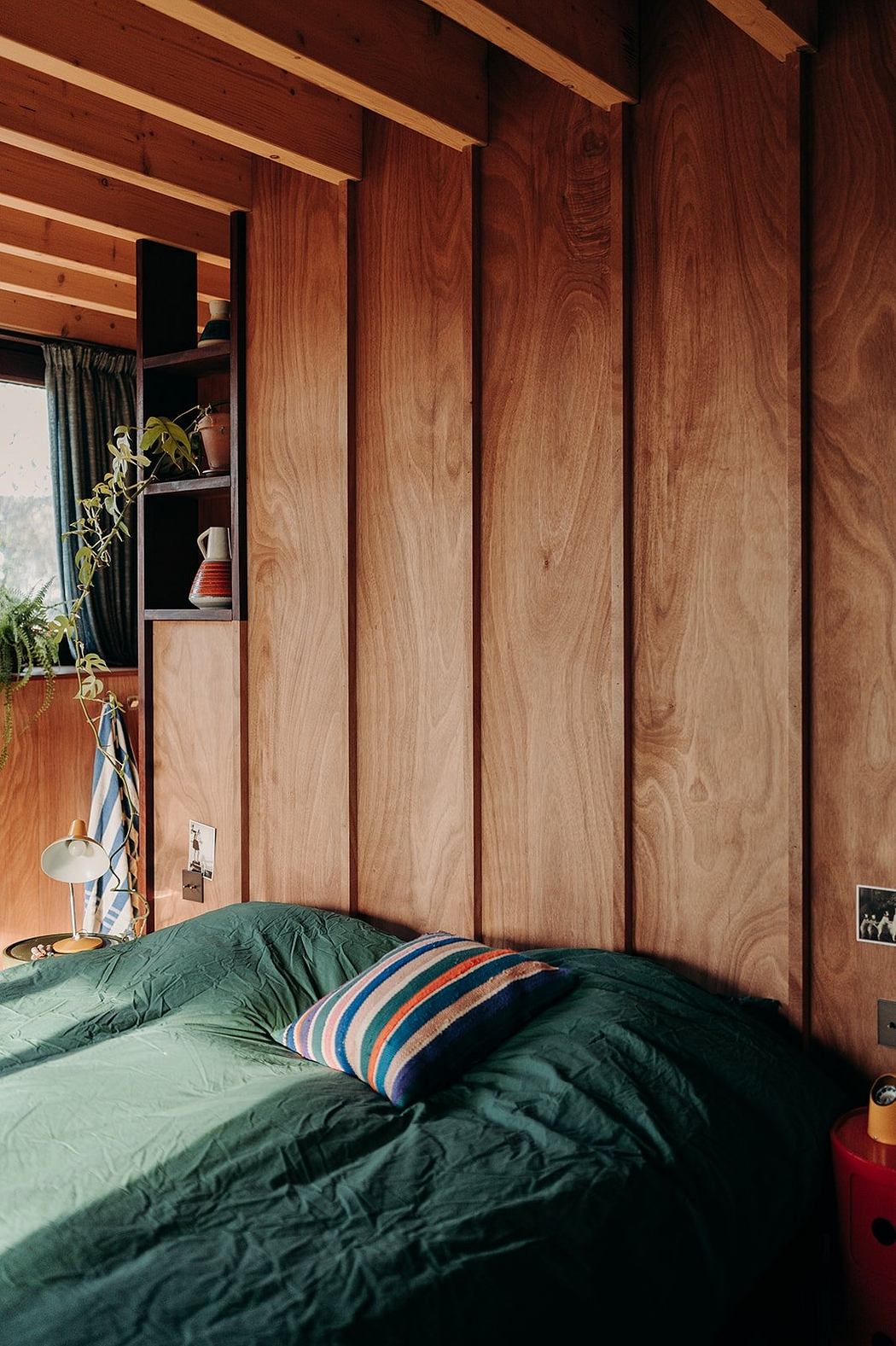 Warm-toned wood paneling and cozy bedding create a rustic, inviting atmosphere.