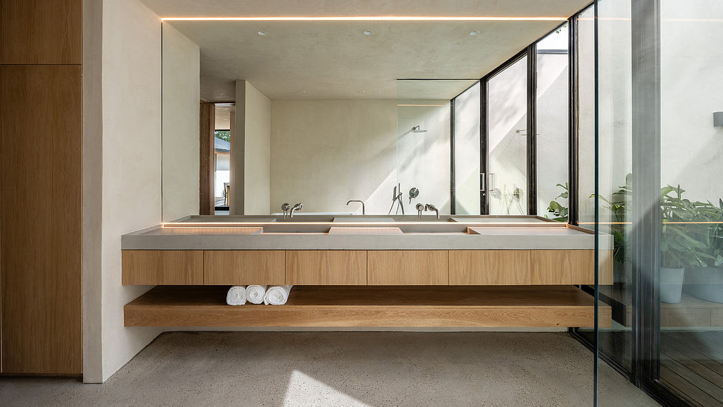 Modern, minimalist bathroom with wooden vanity, floating shelves, and large glass window.