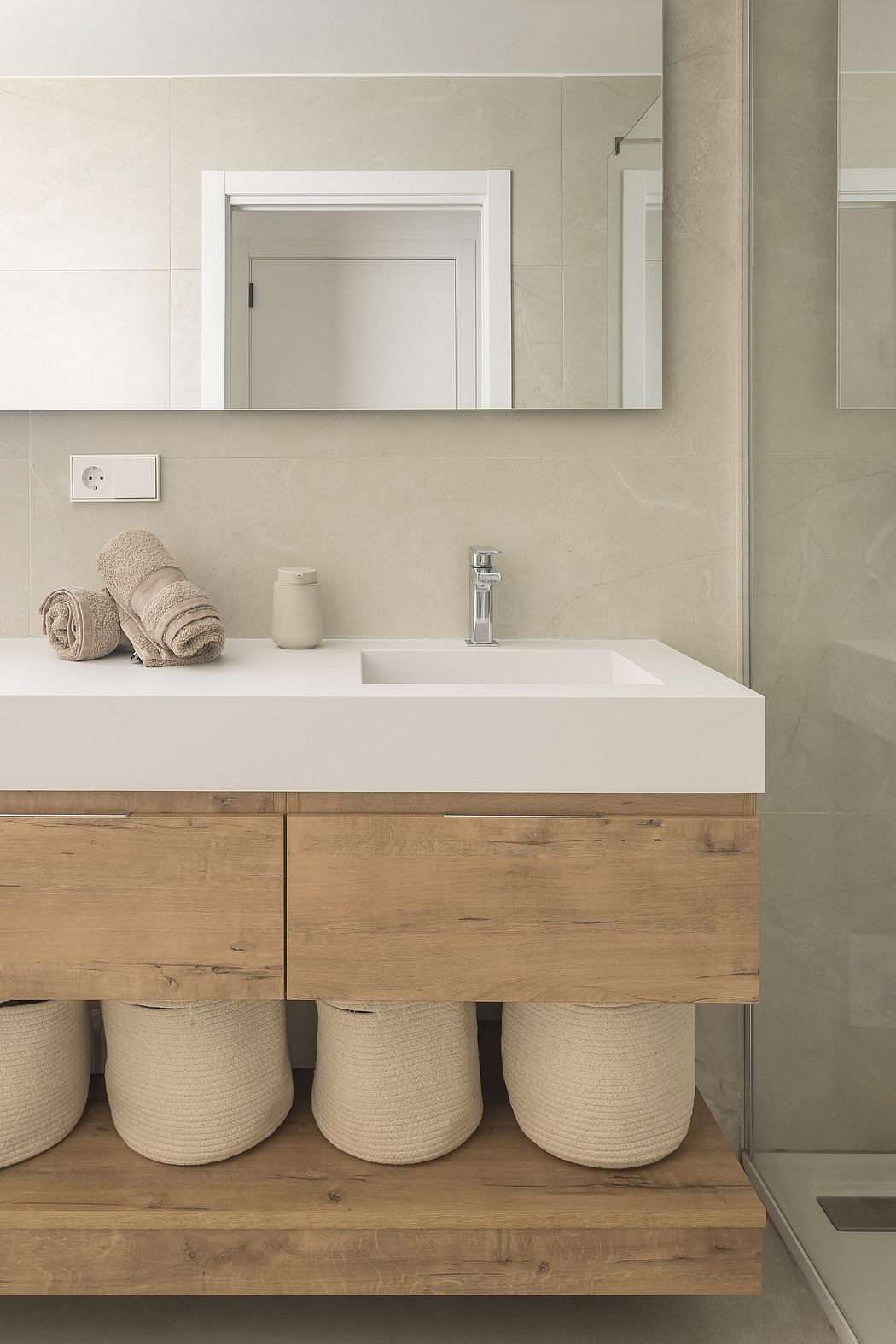 Modern bathroom with sleek vanity, rectangular sink, and floating shelves.