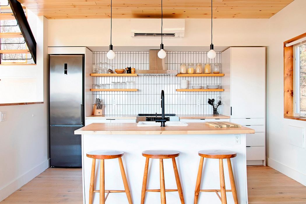 Rustic kitchen with wooden shelves, pendant lights, and a central island with stools.