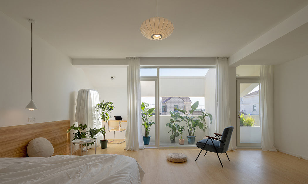 Minimalist bedroom with large windows, natural light, and potted plants decorating the space.