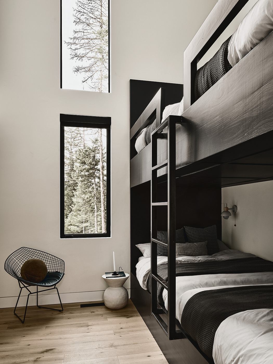 Modern bedroom with minimalist bunk beds, large windows, and sleek black accents.