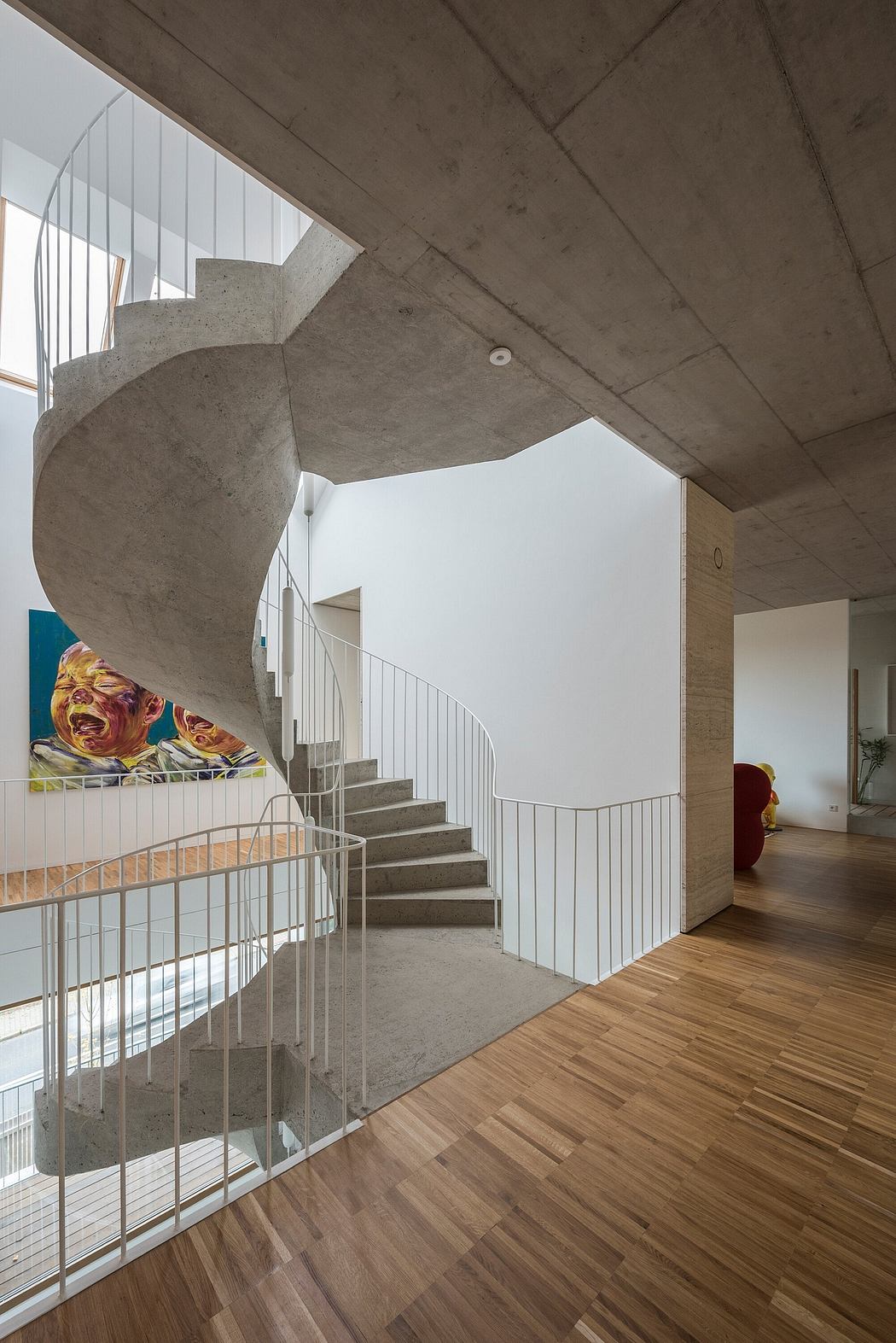 Expansive concrete stairwell with white metal railings in a modern home interior.