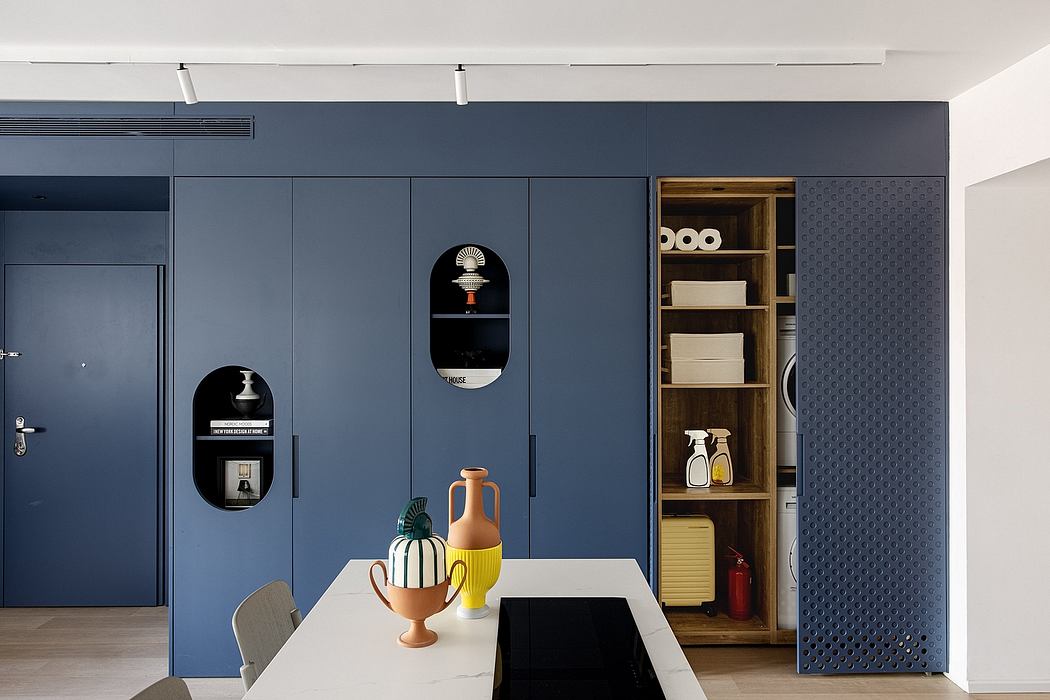 Sleek modern interior with navy blue cabinetry, wood shelving, and pops of color accents.