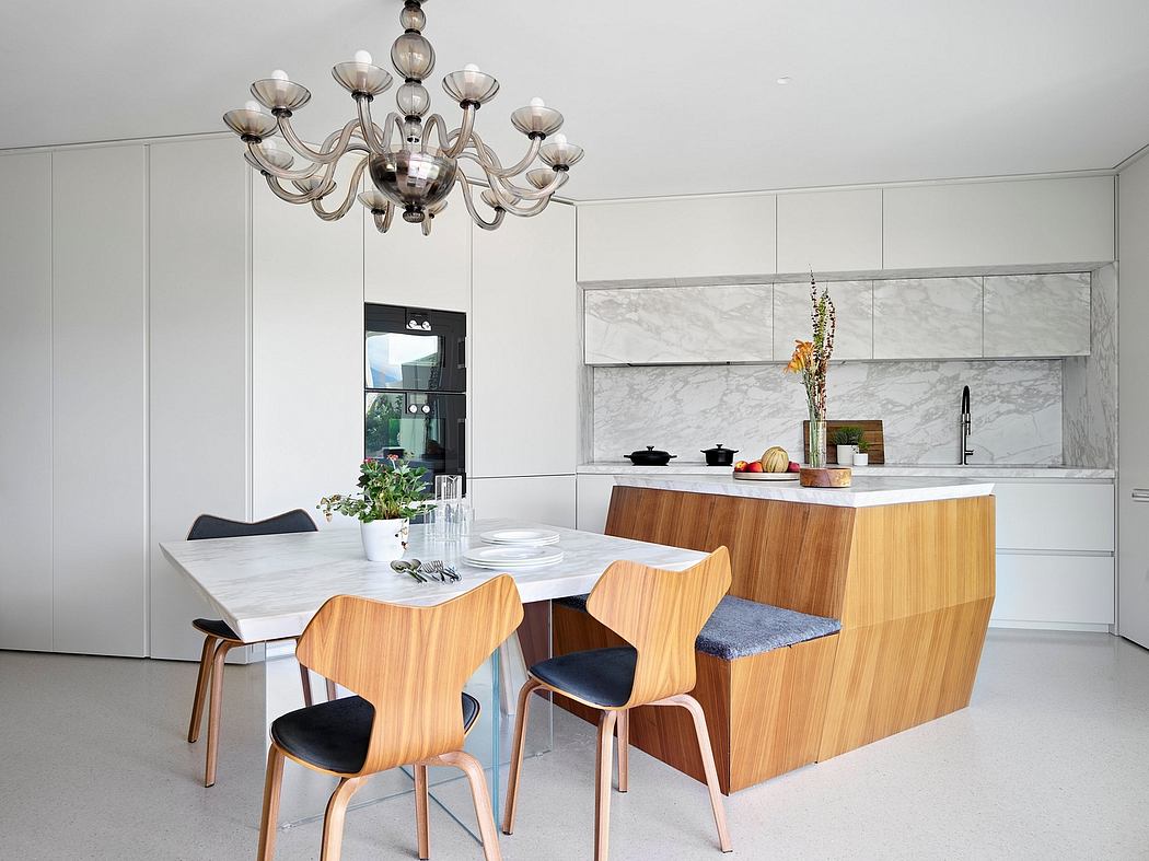 Sleek kitchen-dining room with marble backsplash, wooden island, and midcentury-style chairs.