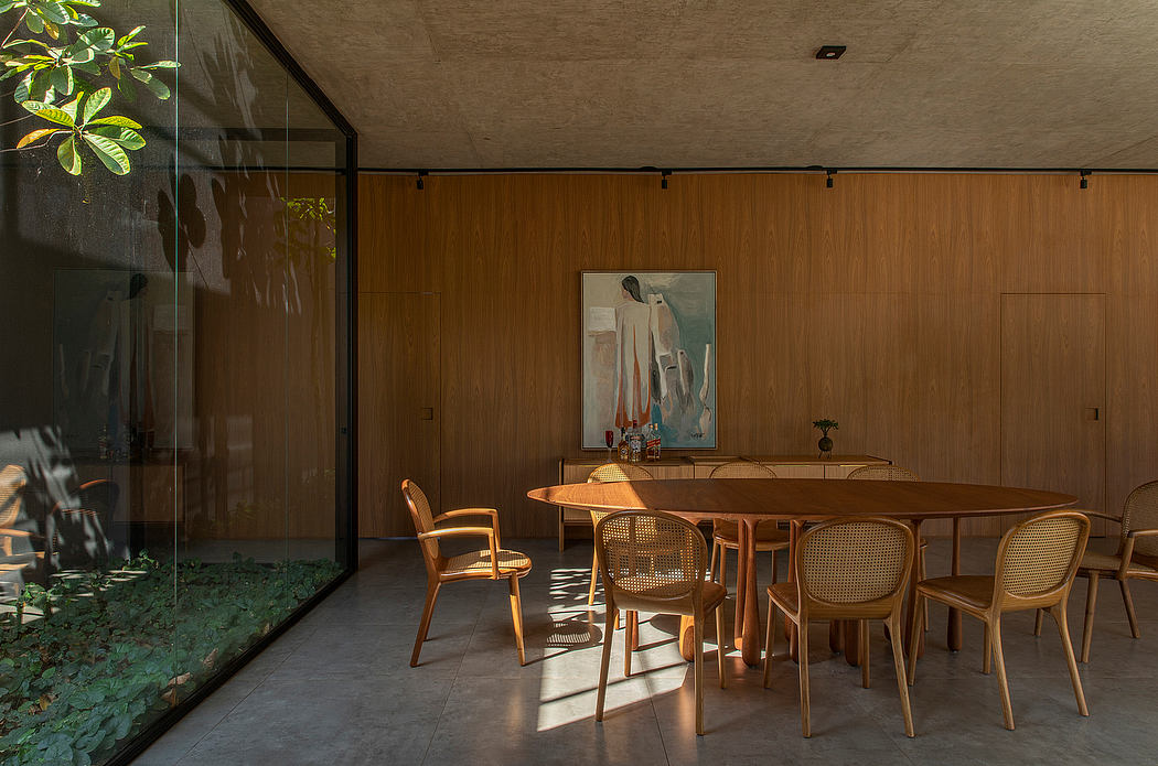 Tranquil midcentury-inspired wood-paneled dining room with abstract artwork and lush greenery.