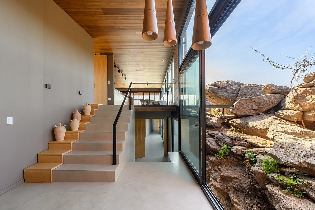 Spacious modern interior with wooden beams, glass walls, and stepped concrete stairs.