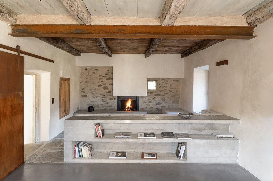 Rustic stone fireplace with wooden ceiling beams and built-in concrete shelves.