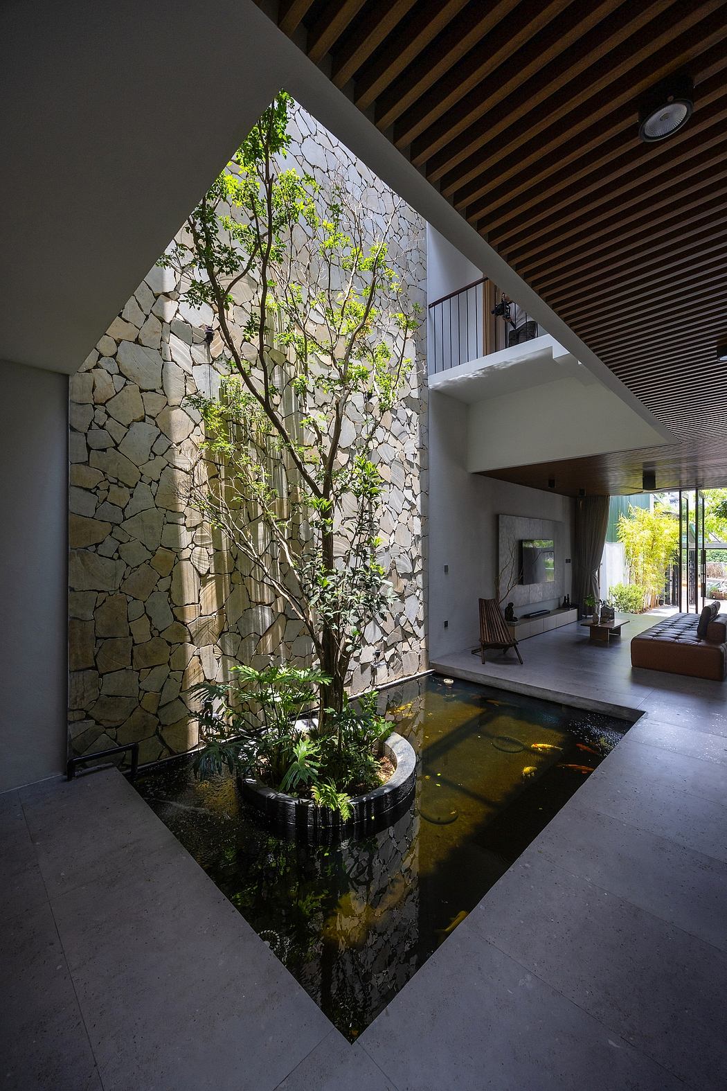 Contemporary stone-walled interior with a central indoor garden and water feature.