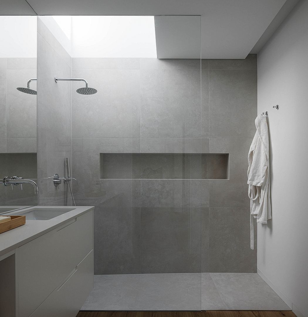Sleek, minimalist bathroom with large shower area, floating vanity, and built-in storage niche.
