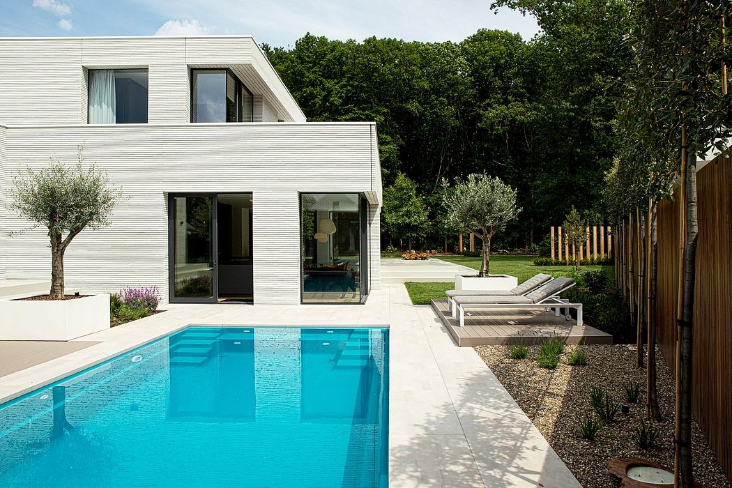 Sleek modern home with swimming pool, patio, and lush landscaped yard.