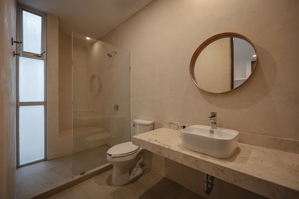 Elegant bathroom with minimalist design, marble countertop, and round mirror.