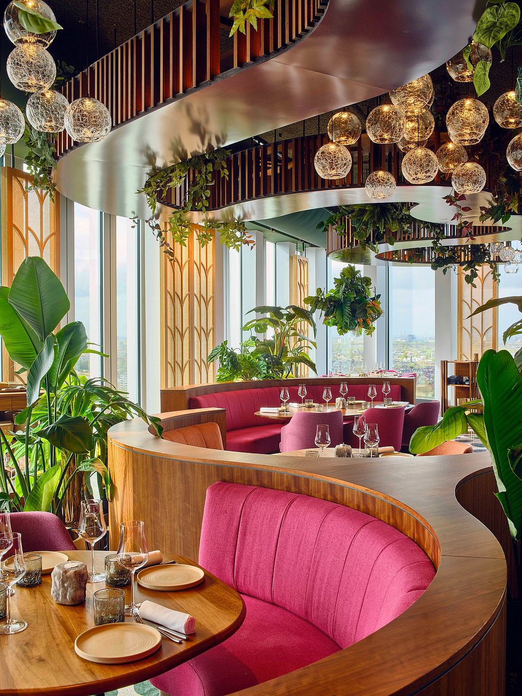 Vibrant tropical-inspired design, with lush greenery, glass walls, and curved seating.