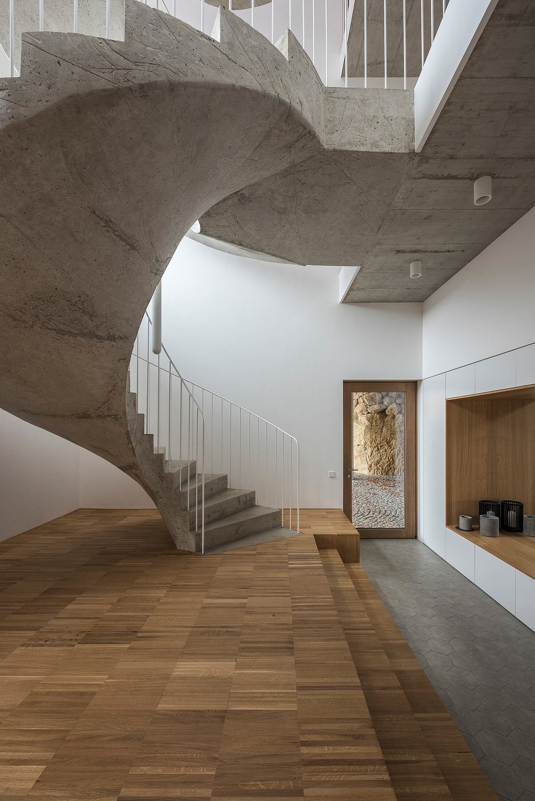 A striking concrete staircase in a minimalist, wood-paneled interior design.