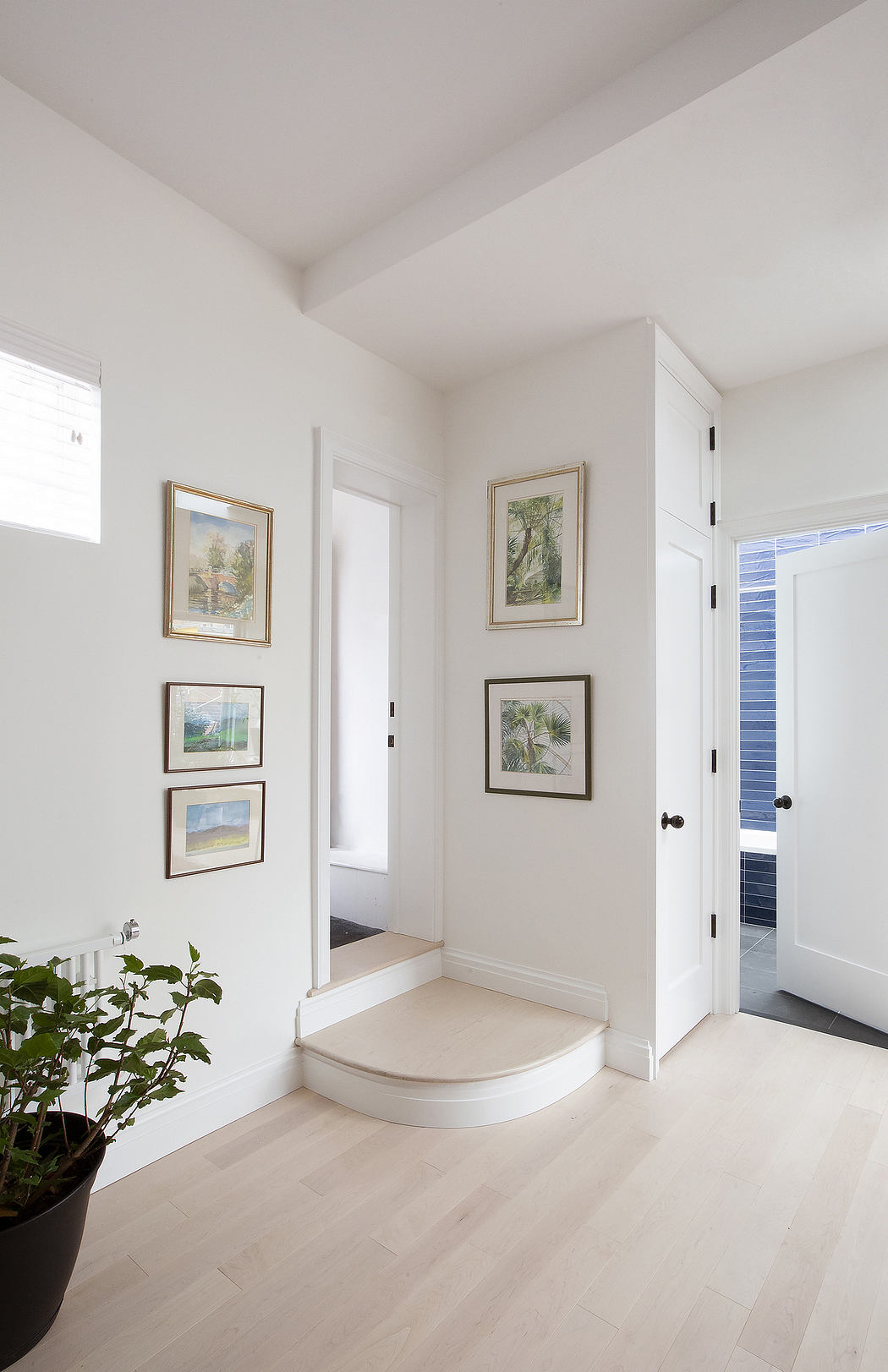 A serene entryway with framed artwork, minimalist decor, and neutral tones.
