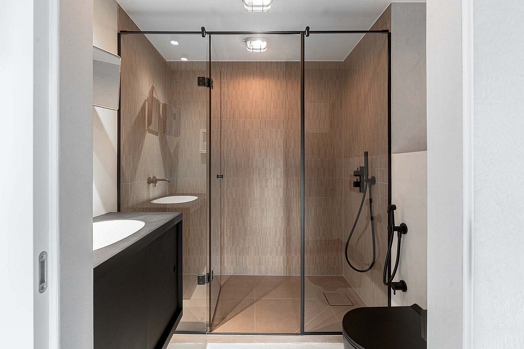Modern bathroom with a glass-enclosed shower, black vanity, and recessed lighting.