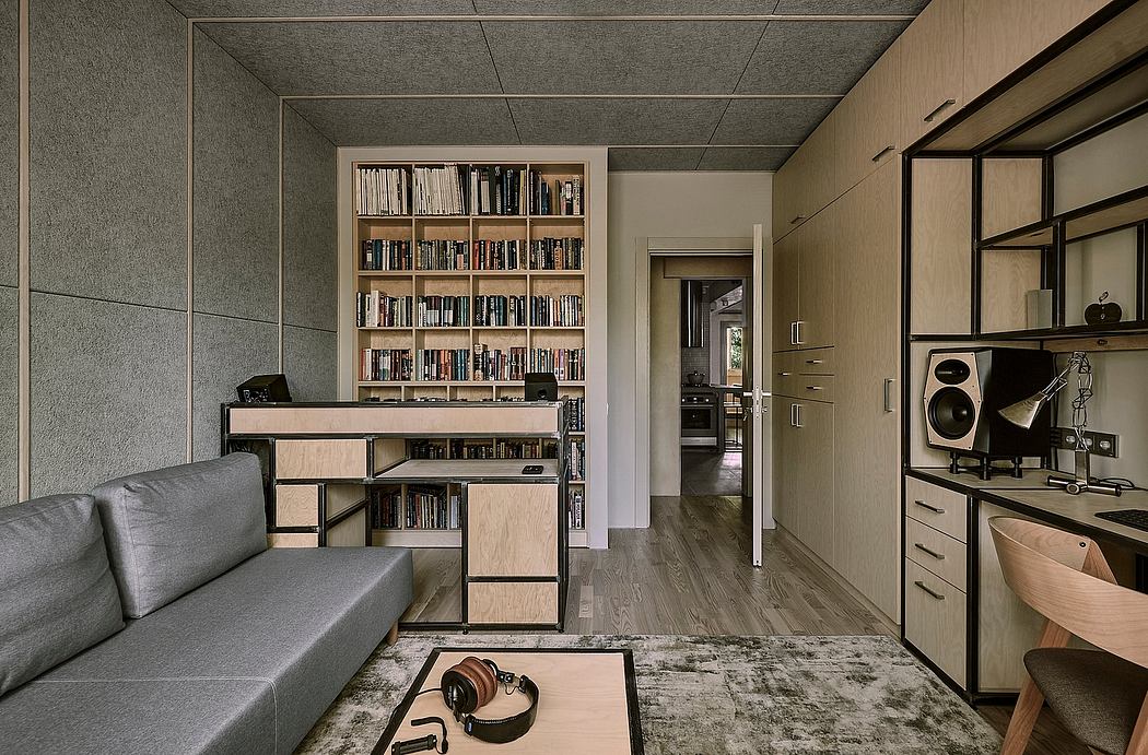 Minimalist living space with built-in bookshelves, gray couch, and audio equipment.