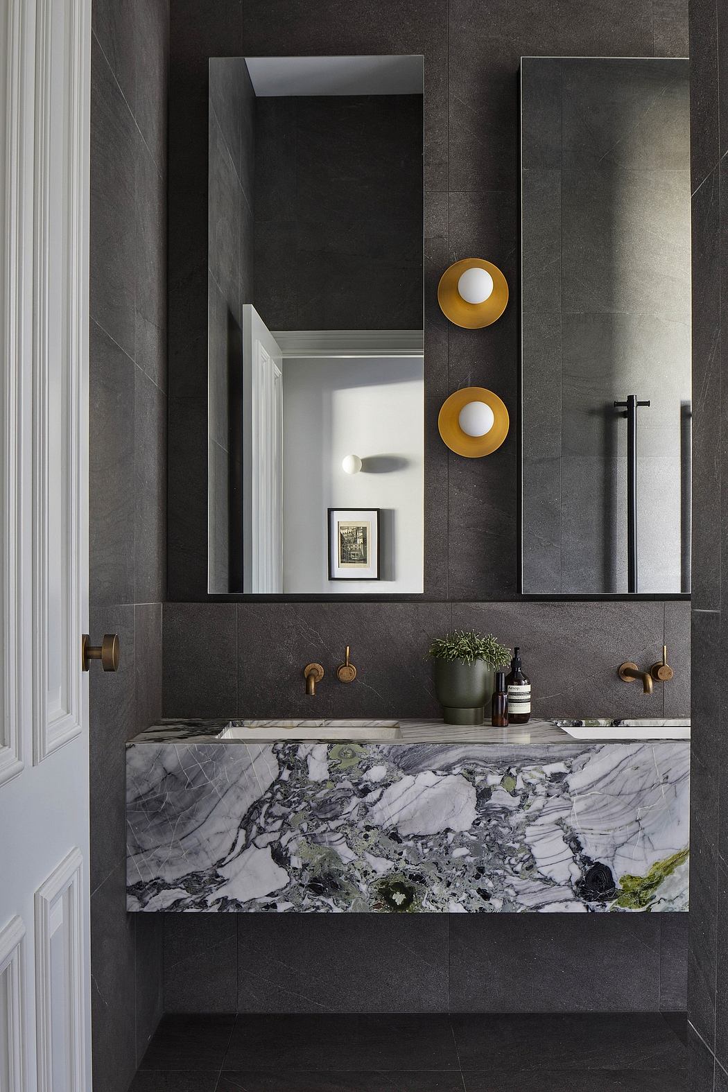 Elegant black and white bathroom with marble vanity and golden accents.