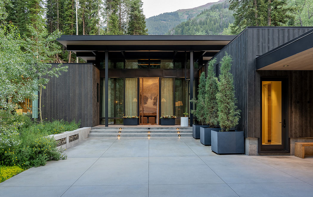 Striking modern architecture featuring glass walls, wooden accents, and a covered porch.