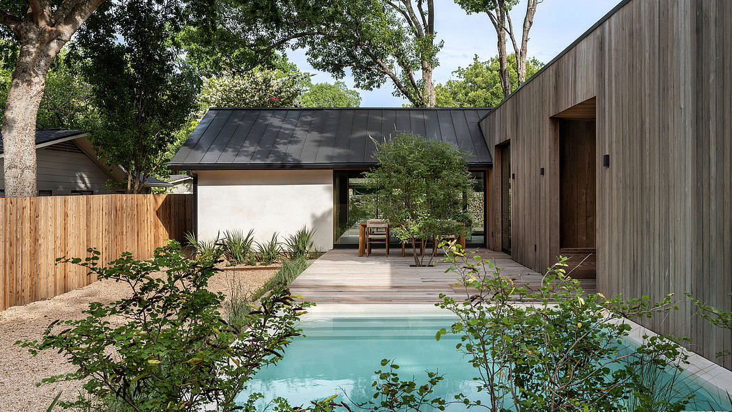 A modern backyard oasis with a wooden pavilion, pool, and lush greenery.