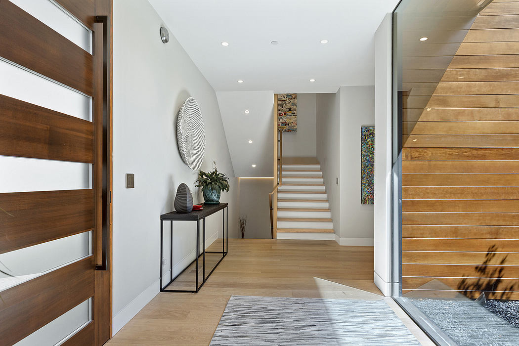 Spacious modern entryway with wooden paneled walls, recessed lighting, and minimal decor.