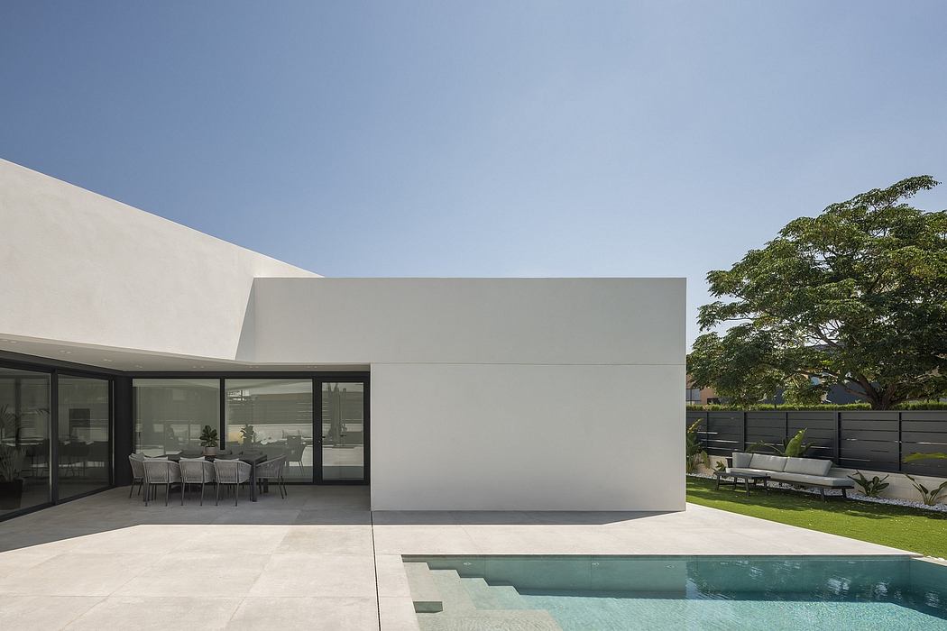 Sleek, minimalist architecture with clean lines, large windows, and a swimming pool.