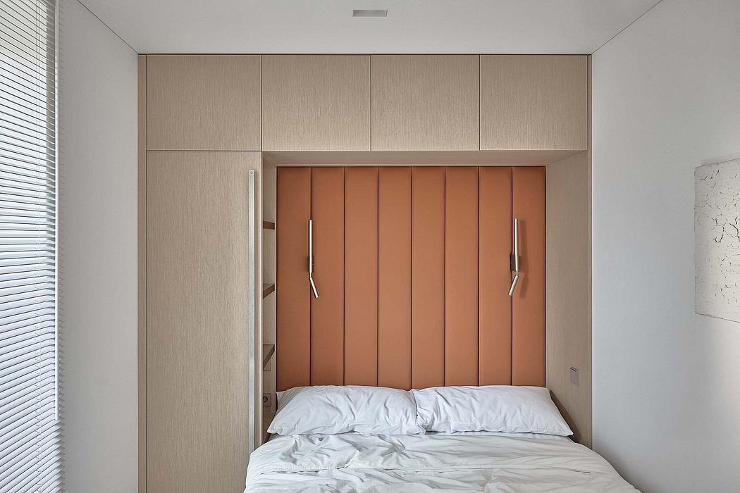 Minimalist bedroom with built-in wooden headboard and cabinets, modern and sleek design.