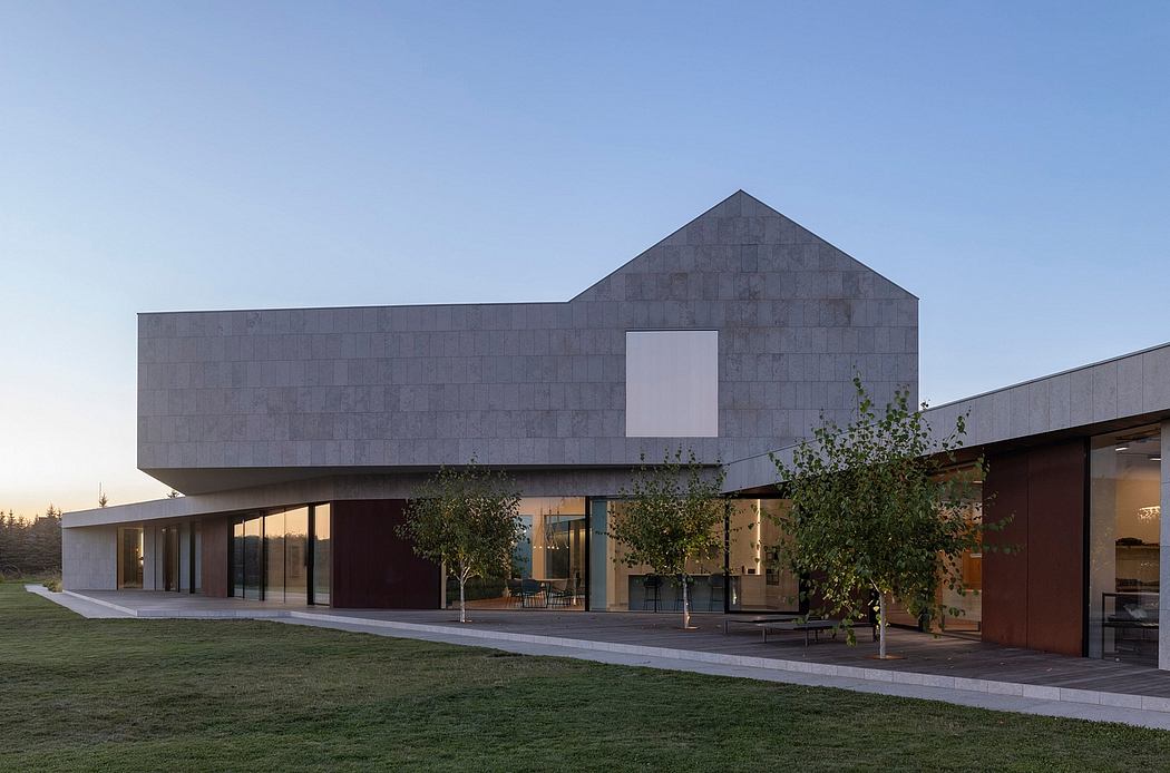 Modern architectural design with clean lines, stone facade, and large glass windows.