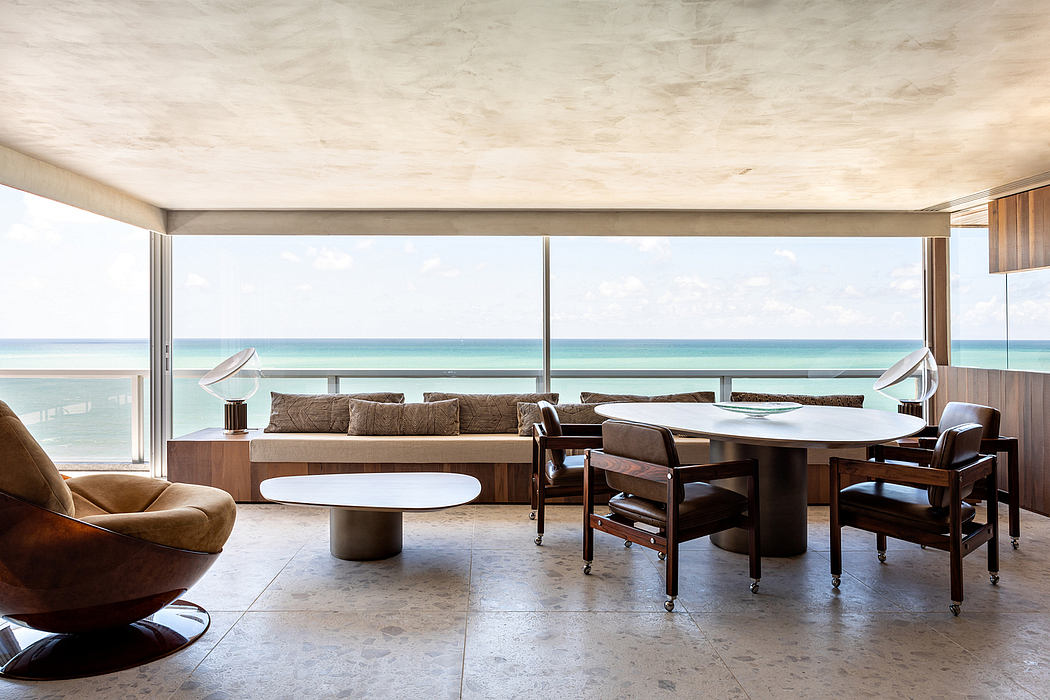 Spacious living area with floor-to-ceiling windows overlooking a serene, turquoise ocean.
