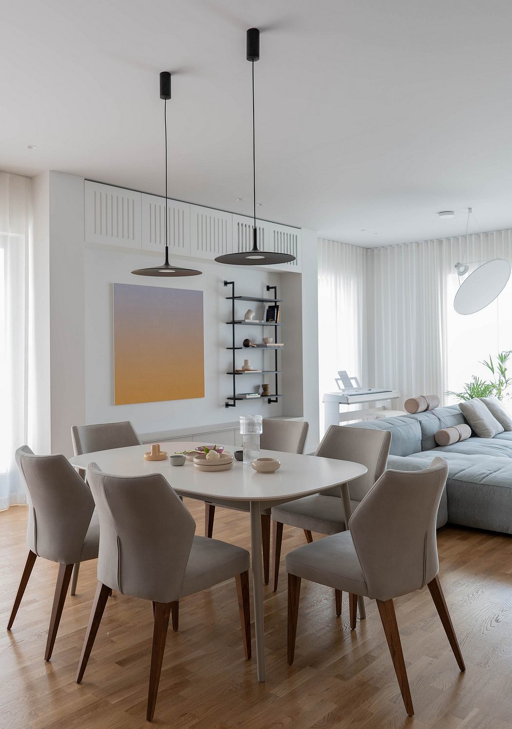 Modern dining room with pendant lights, minimalist shelving, and neutral furnishings.