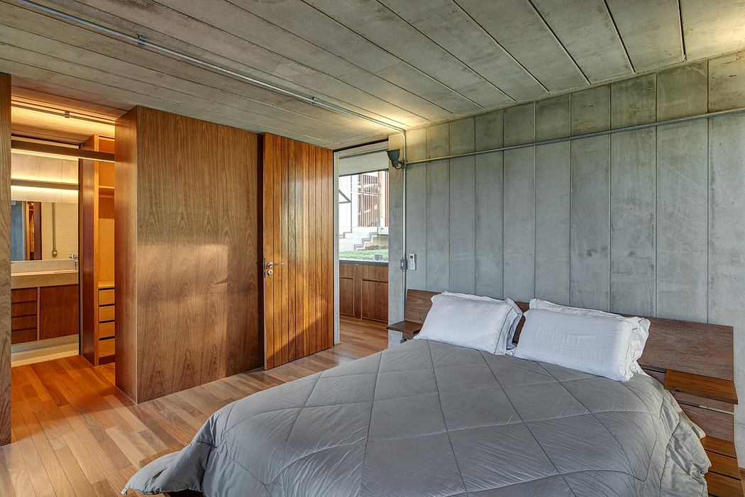 Minimalist, earthy-toned bedroom with exposed concrete walls and wooden furnishings.