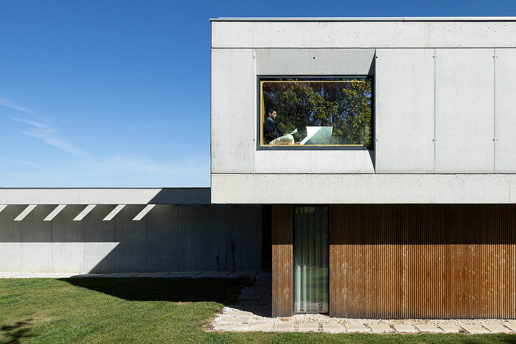 Contemporary architectural design with concrete, wood, and expansive glass elements.