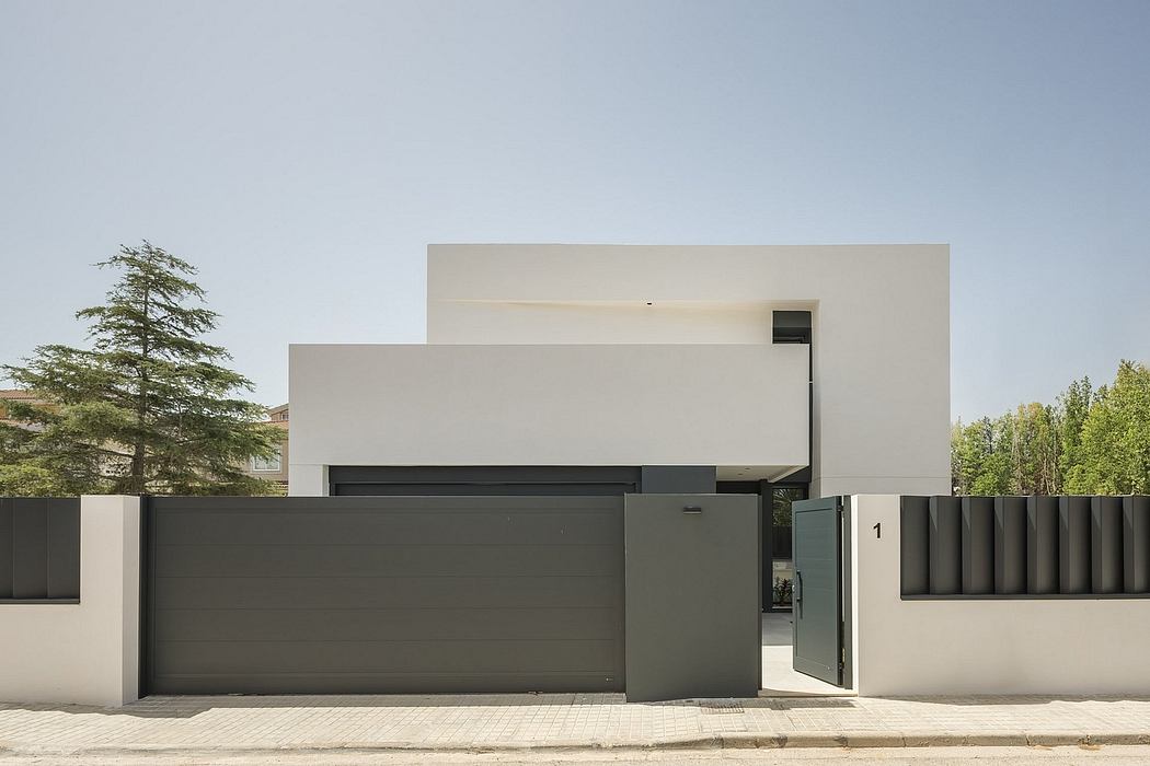 Modern minimalist architecture with a sleek gray garage door and white exterior walls framing the entrance.