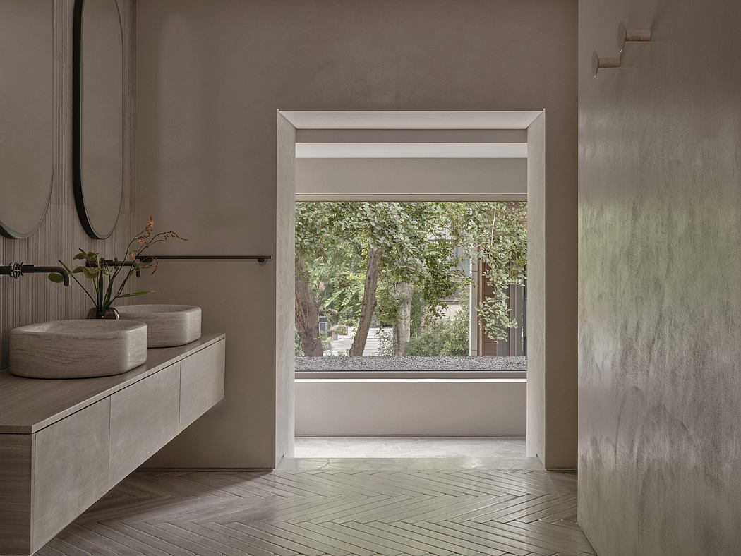 A modern, minimalist bathroom with a large window framing the lush greenery outside.