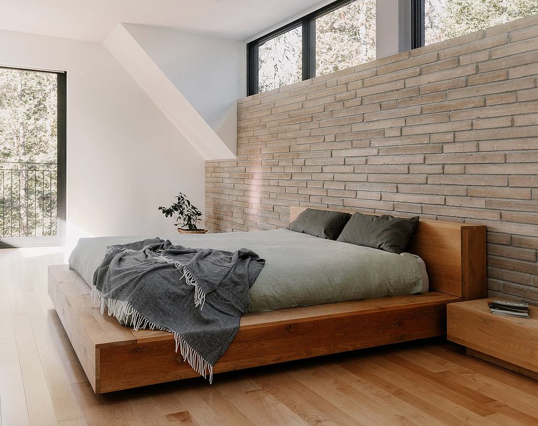 Warm-toned wood bed frame and brick accent wall in minimalist bedroom setting.
