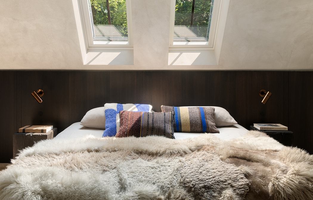 Well-designed modern bedroom with cozy textures, wood paneling, and natural light from large windows.