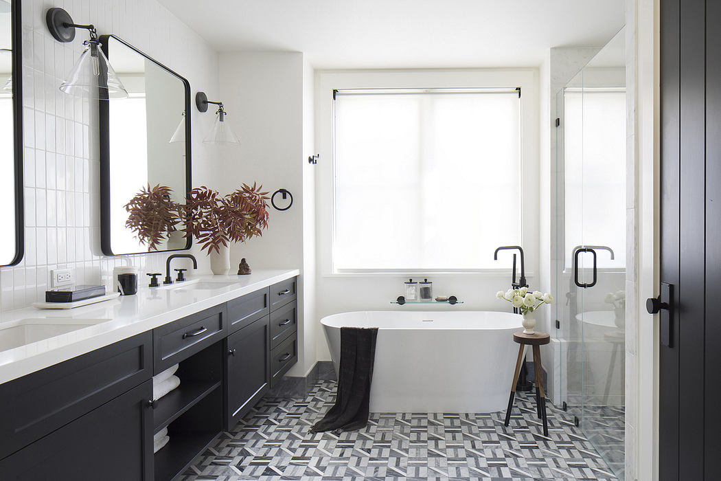 Spacious, contemporary bathroom with sleek vanity, standalone tub, and patterned floor tiles.