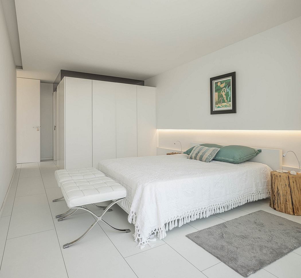 Minimalist bedroom design with clean lines, white bedding, and a modern art piece.