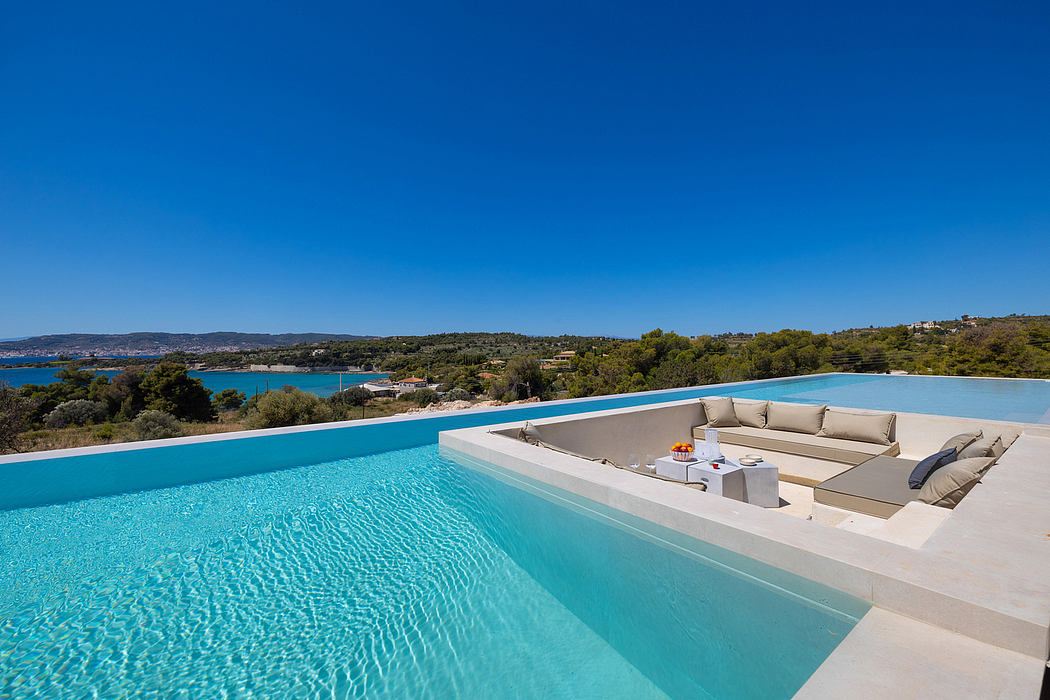 Stunning infinity pool with luxurious lounge area and breathtaking coastal views.