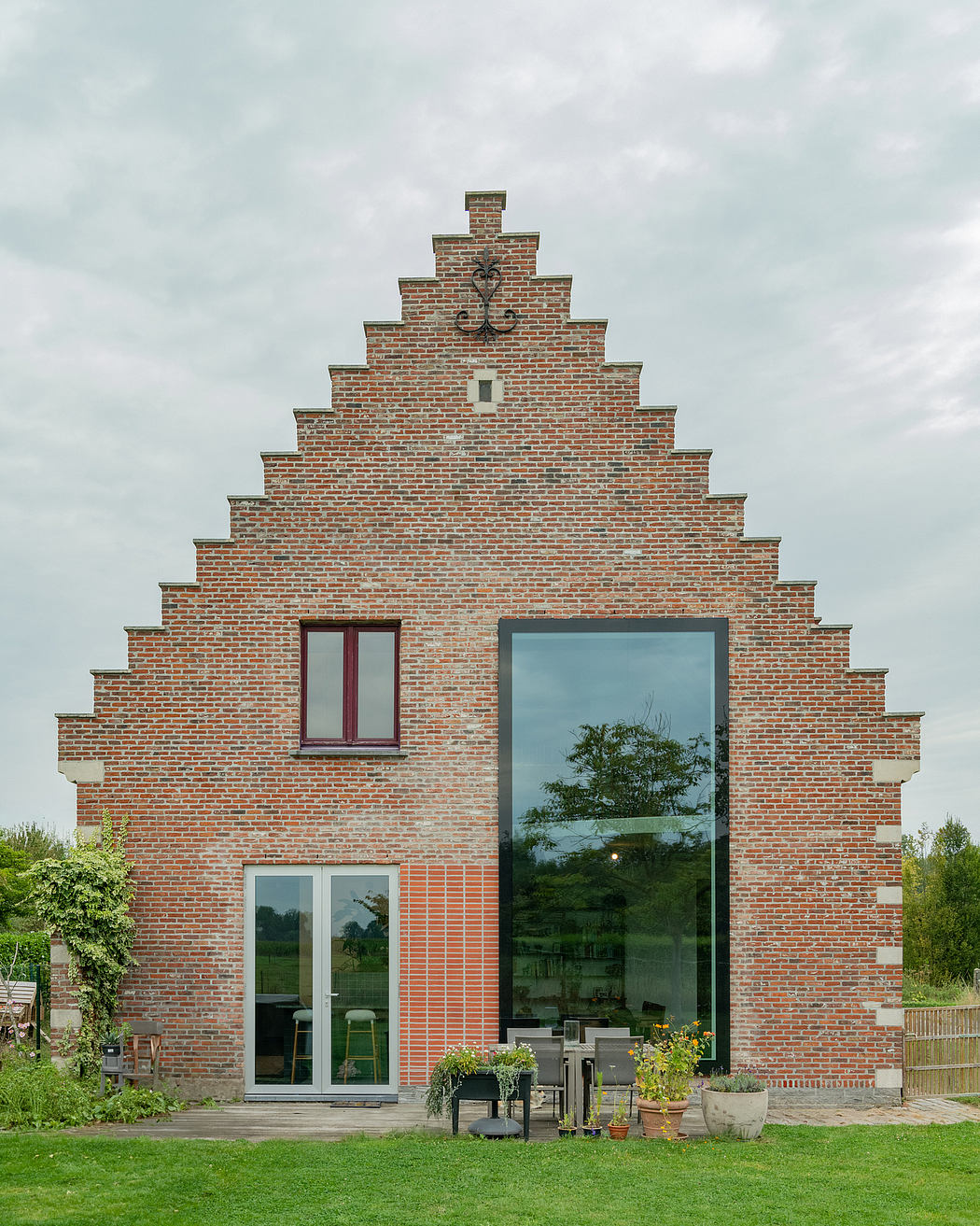 Striking brick facade with stepped gables, ornamental accents, and large glass panels.